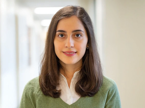 A woman with brown hair wears a green shirt.