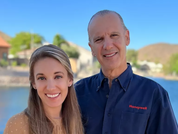 two people, smiling, pond of water in background