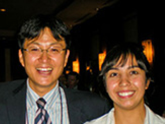 man and woman smiling, wearing lanyards