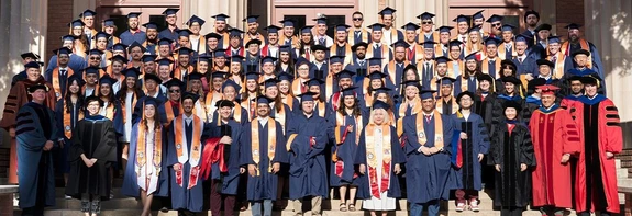 group of people, standing on steps, dressed in graduation regallia