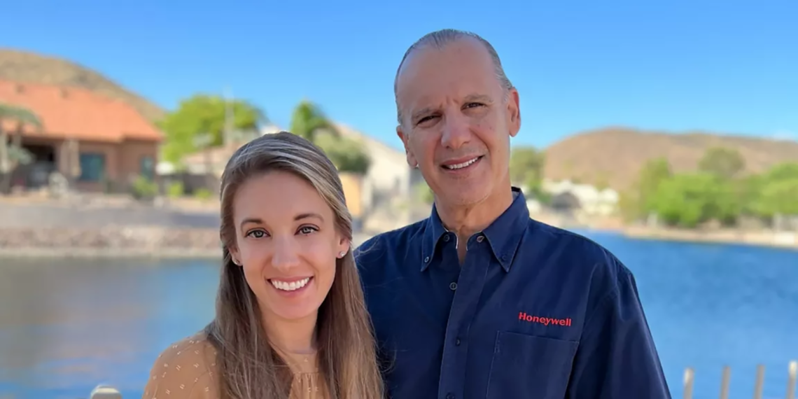 two people, smiling, pond of water in background