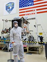 Bradley Williams with the OSIRIS-REx spacecraft in the Lockheed Martin cleanroom. Photo by Symeon Platts/The University of Arizona.