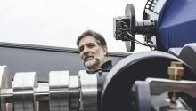 Roberto Furfaro, peeking out from behind a large telescope.