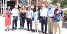 Eight new engineering faculty members stand in the AME courtyard wearing festive leis.