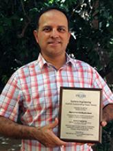 Ricardo Valerdi holds the plaque honoring him for best paper in the journal Systems Engineering