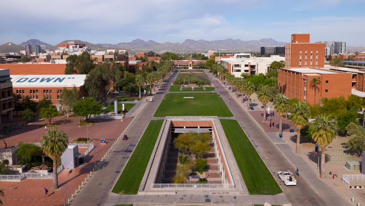 A bird's eye view of the University of Arizona mall with mountains in the distance